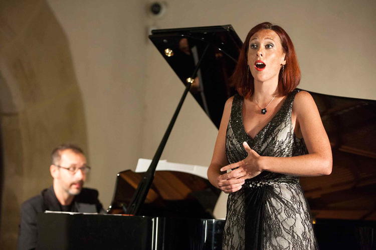 Female singer in a recital dress by a piano