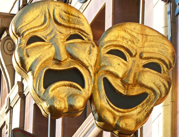 comedy and tragedy masks hanging outside a theater