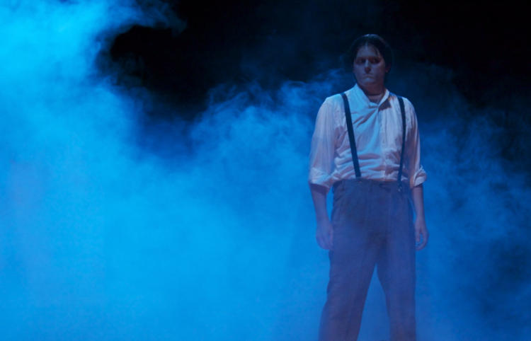 Male actor on a foggy stage in a dark horror musical