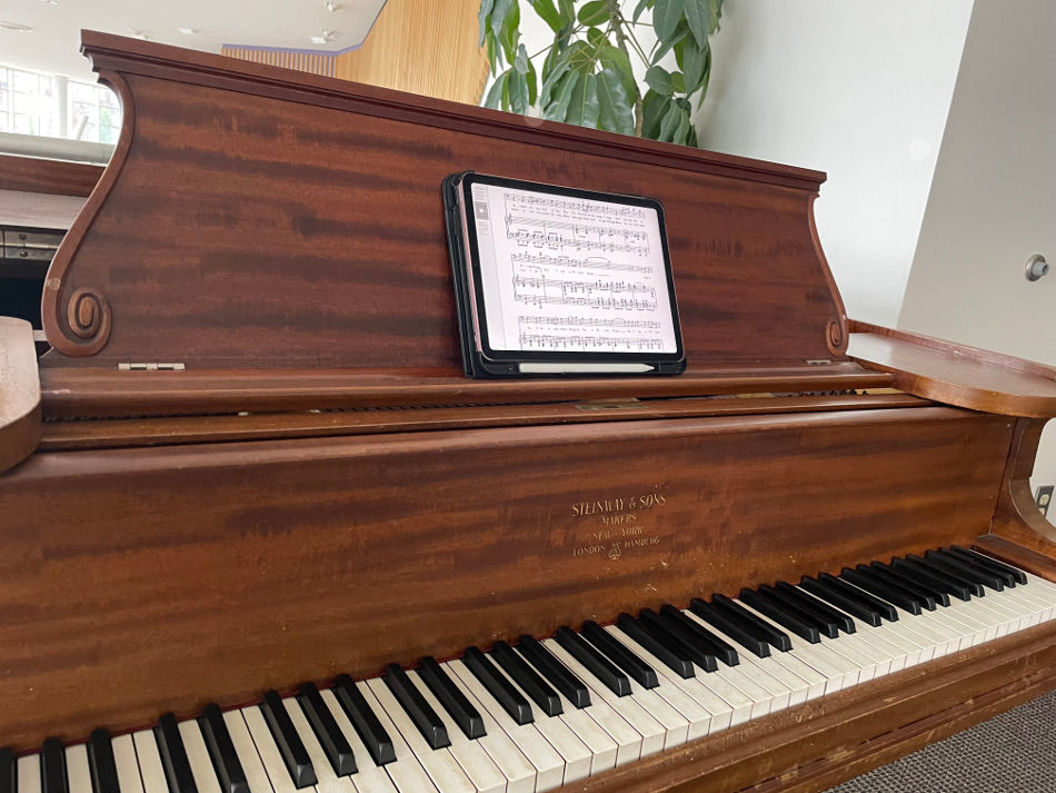 wood piano with an iPad showing audition sheet music