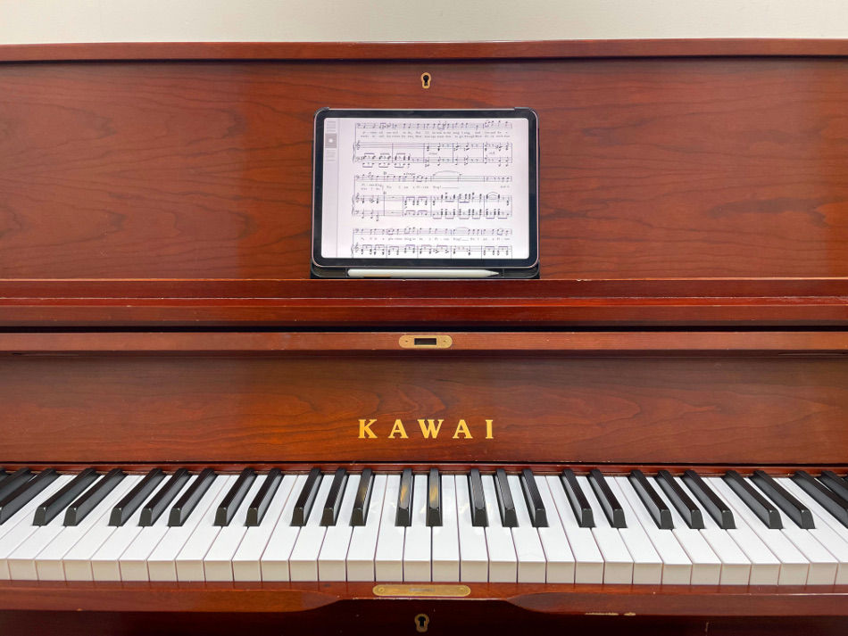 brown Steinway piano with an iPad displaying musical theater audition music